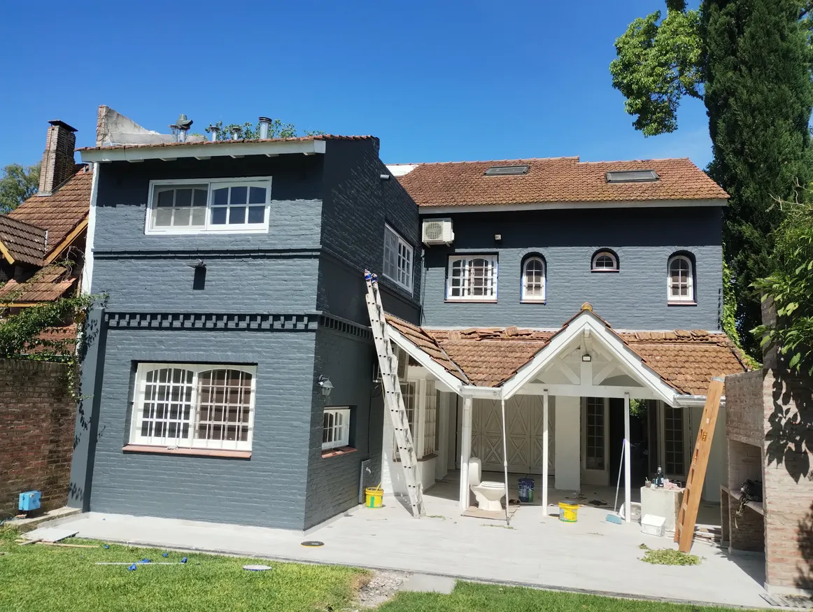 Pintura exterior profesional en casa de Tigre — terminación con recubrimiento plástico